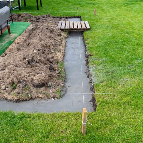 Foundation footings poured in a ditch in the yard, building a terrace in the backyard.